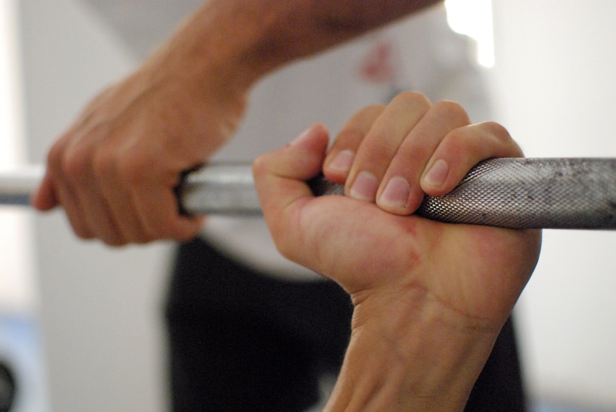 Een arts meet de handkracht van een persoon met een handdynamometer.